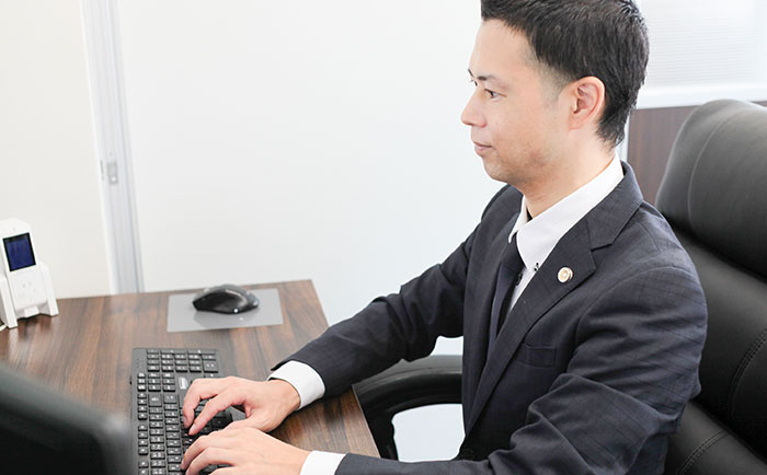法律文書を作成する四元弁護士
